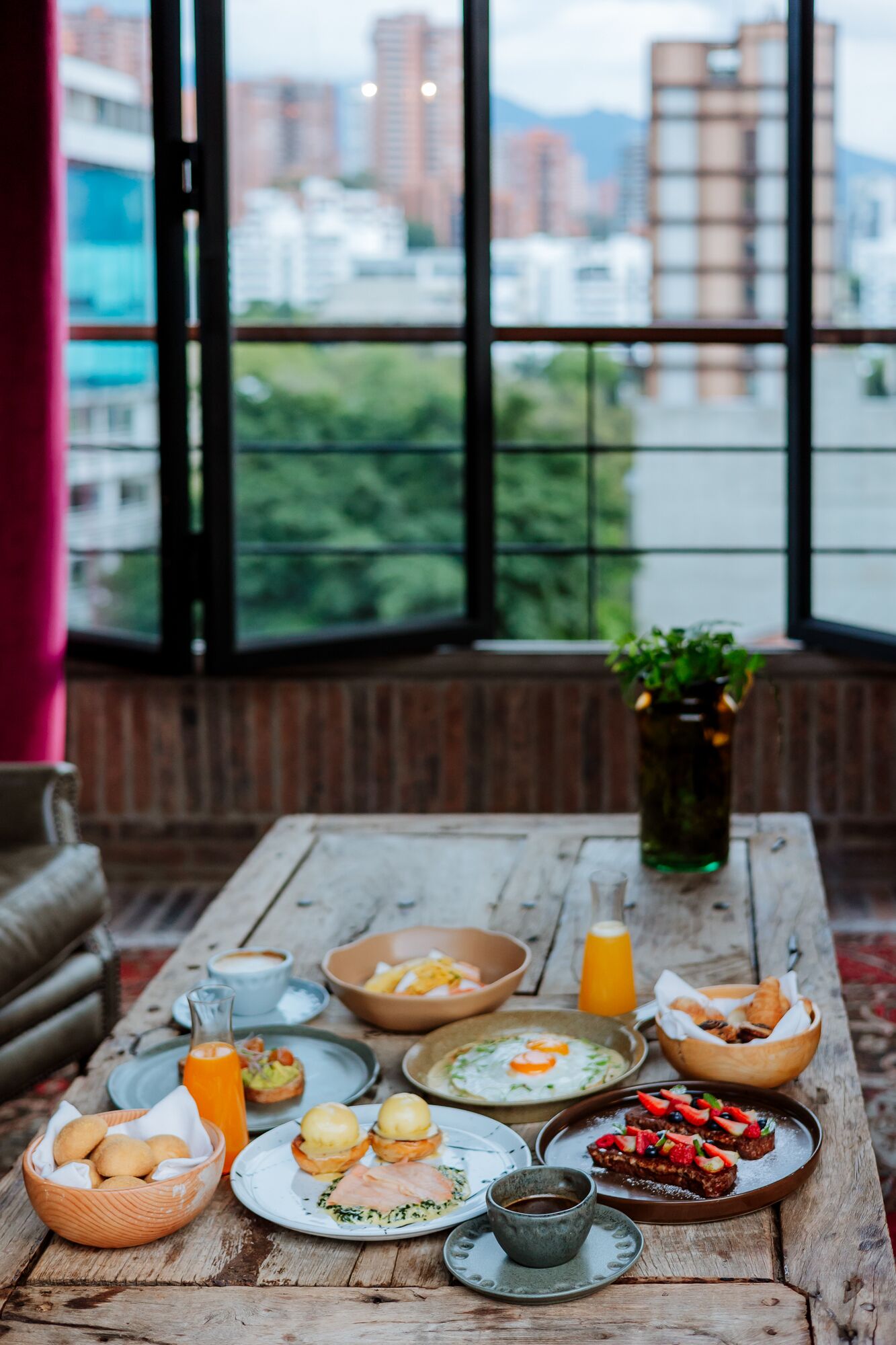 Ein Frühstückstisch mit verschiedenen Speisen, einer Kaffeetasse und einem Glas Orangensaft.