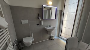 A modern bathroom with a toilet, sink, and shower. - Therra Lodge (Preganziol)