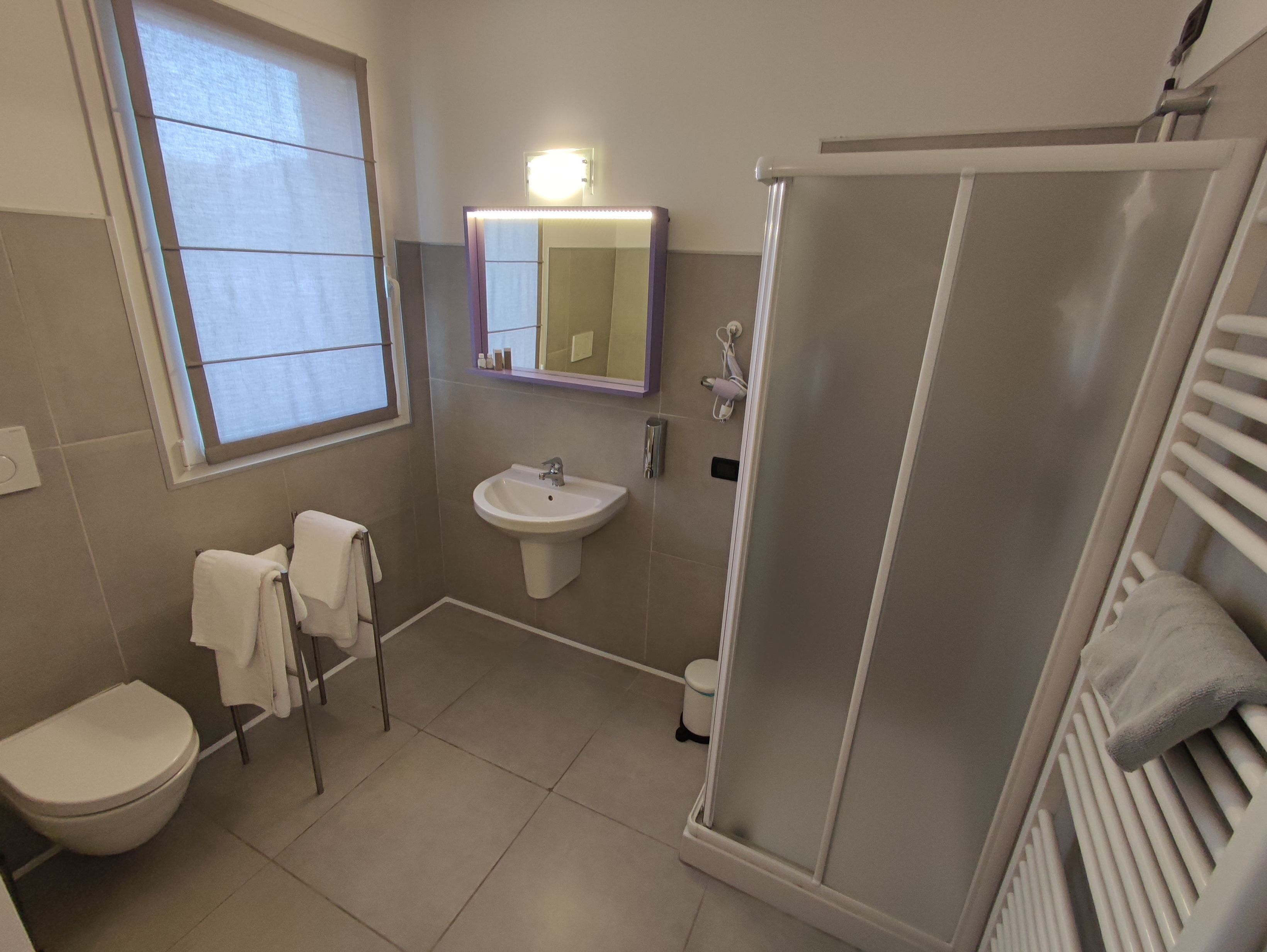 A bathroom with a toilet, sink, and shower.