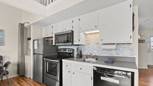 A modern kitchen with stainless steel appliances, white cabinetry, and a tiled backsplash. - 237 Beautiful deck view, close to strip and Marina (Branson)