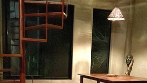 A room with a wooden table and chairs, a hanging light fixture, and a window with a view. - CASA TÚA, amazing views just minutes to the beach! (Puerto Escondido)