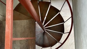A spiral staircase with a red metal handrail and a glass enclosure. - CASA TÚA, amazing views just minutes to the beach! (Puerto Escondido)