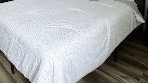 Une chambre à coucher avec un lit, une table de chevet et une porte donnant sur une autre pièce.