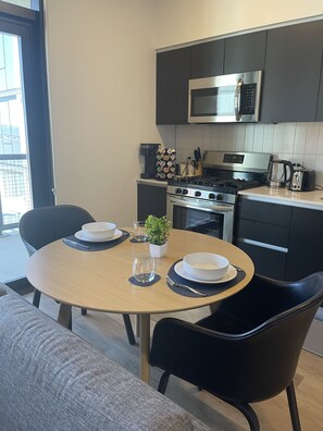 Enjoy meals in the kitchen with a gas stove, microwave, and coffee machine, and dine at the round table with four chairs.
