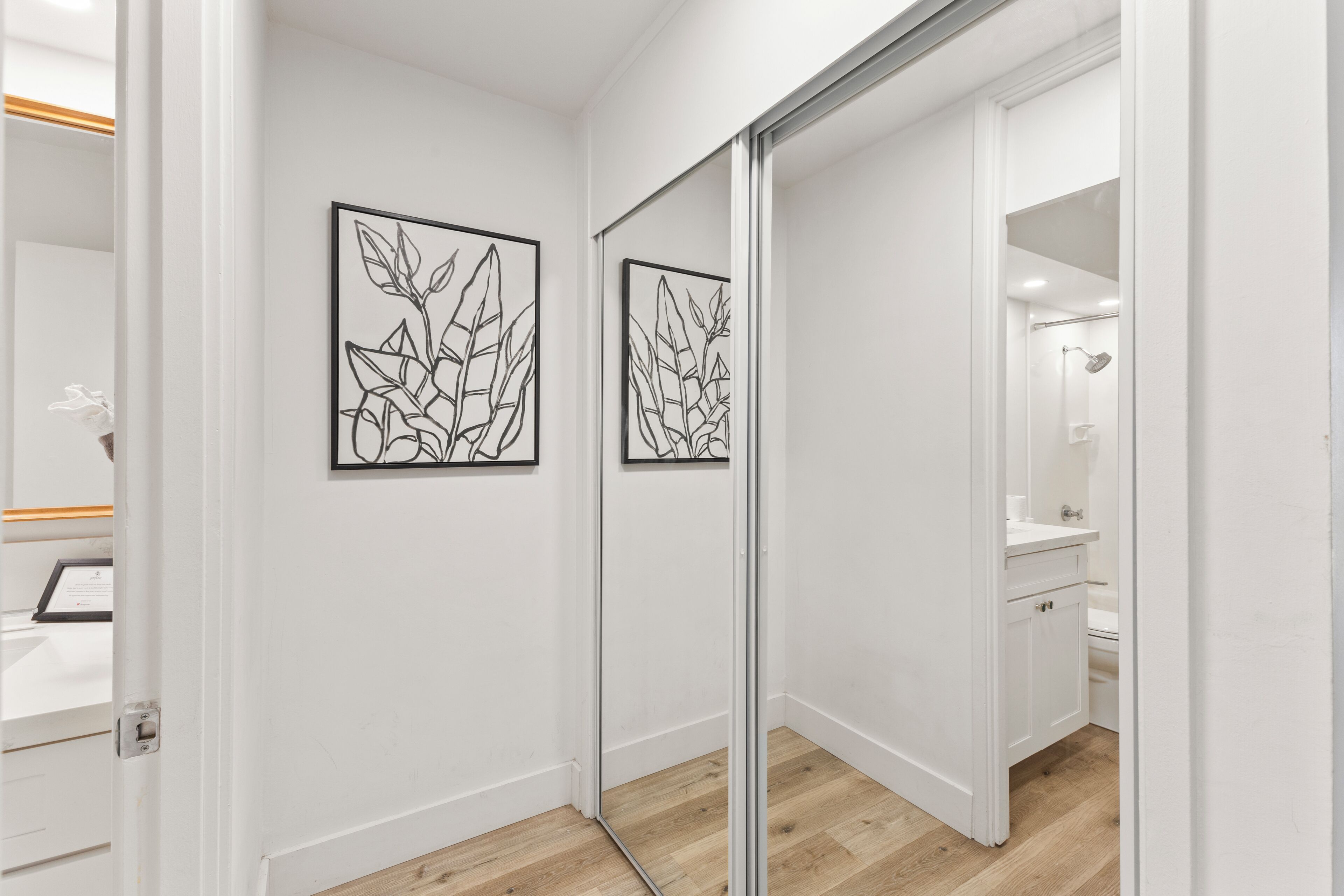 A modern bathroom with a glass shower enclosure, a white sink, and a mirror.