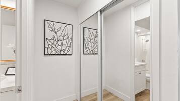 A modern bathroom with a glass shower enclosure, a white sink, and a mirror.