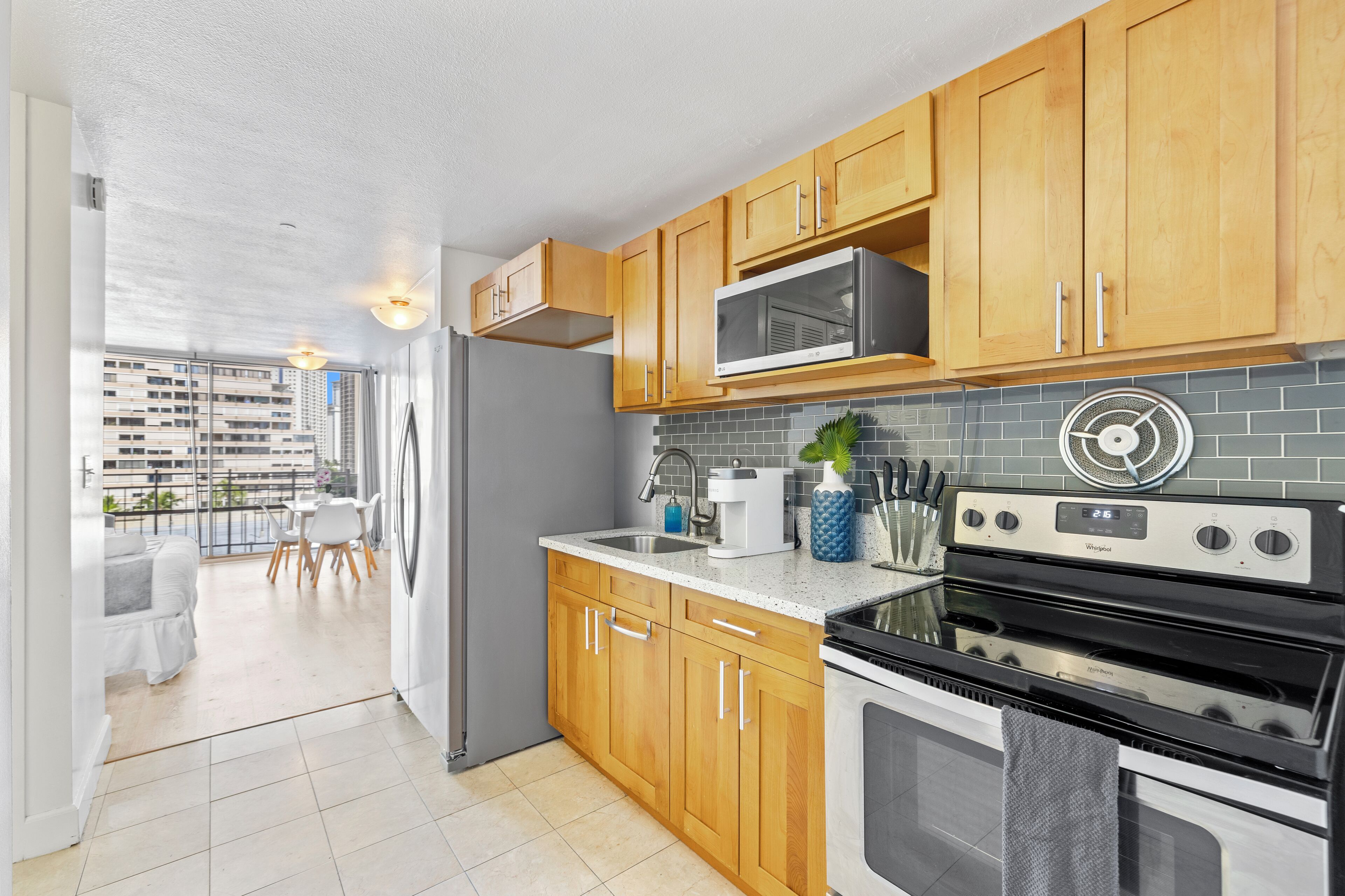 A modern kitchen with wooden cabinets, a microwave, a stove, and a sink.