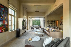 A spacious living room with a fireplace, a sofa set, a coffee table, and a television.