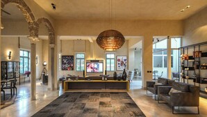 A spacious living area with a large rug, seating, artwork, and a television. - The Pearl of Jaffa: 3BR Luxury with Patio (Tel Aviv-Yafo)