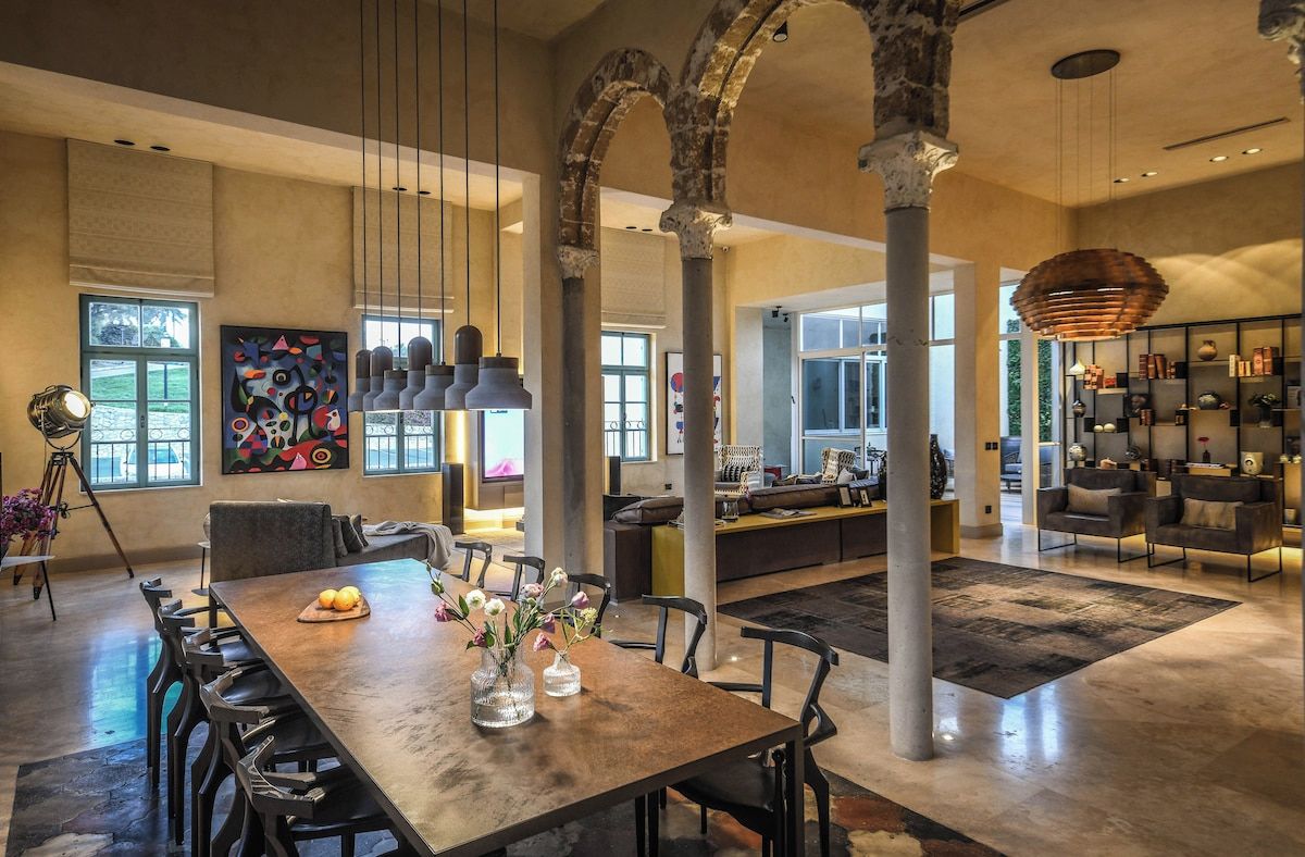 A spacious interior with a dining area, seating, and a kitchen in the background.