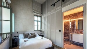A bedroom with a large bed, a wardrobe, a bathroom with a shower, and a view of the outside. - The Pearl of Jaffa: 3BR Luxury with Patio (Tel Aviv-Yafo)