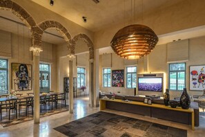 A spacious interior with a large TV, seating area, and natural light from windows.