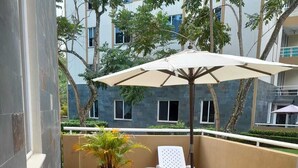Eine Terrasse im Freien mit einem runden Tisch und Stühlen, umgeben von Blumentöpfen.