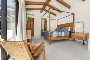 A bedroom with a four-poster bed, wooden furniture, and a view through a window. - Luxury Panoramic Ocean View Private Pool @Coronado (Cabo San Lucas)