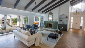 A spacious living room with a fireplace, a dining area, and a view of the outdoors. - Southern Highlands Finest! (Exeter)
