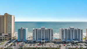 Ein Hotel direkt am Strand mit mehreren Hochhäusern, Parkplätzen und freiem Blick auf den Ozean.
