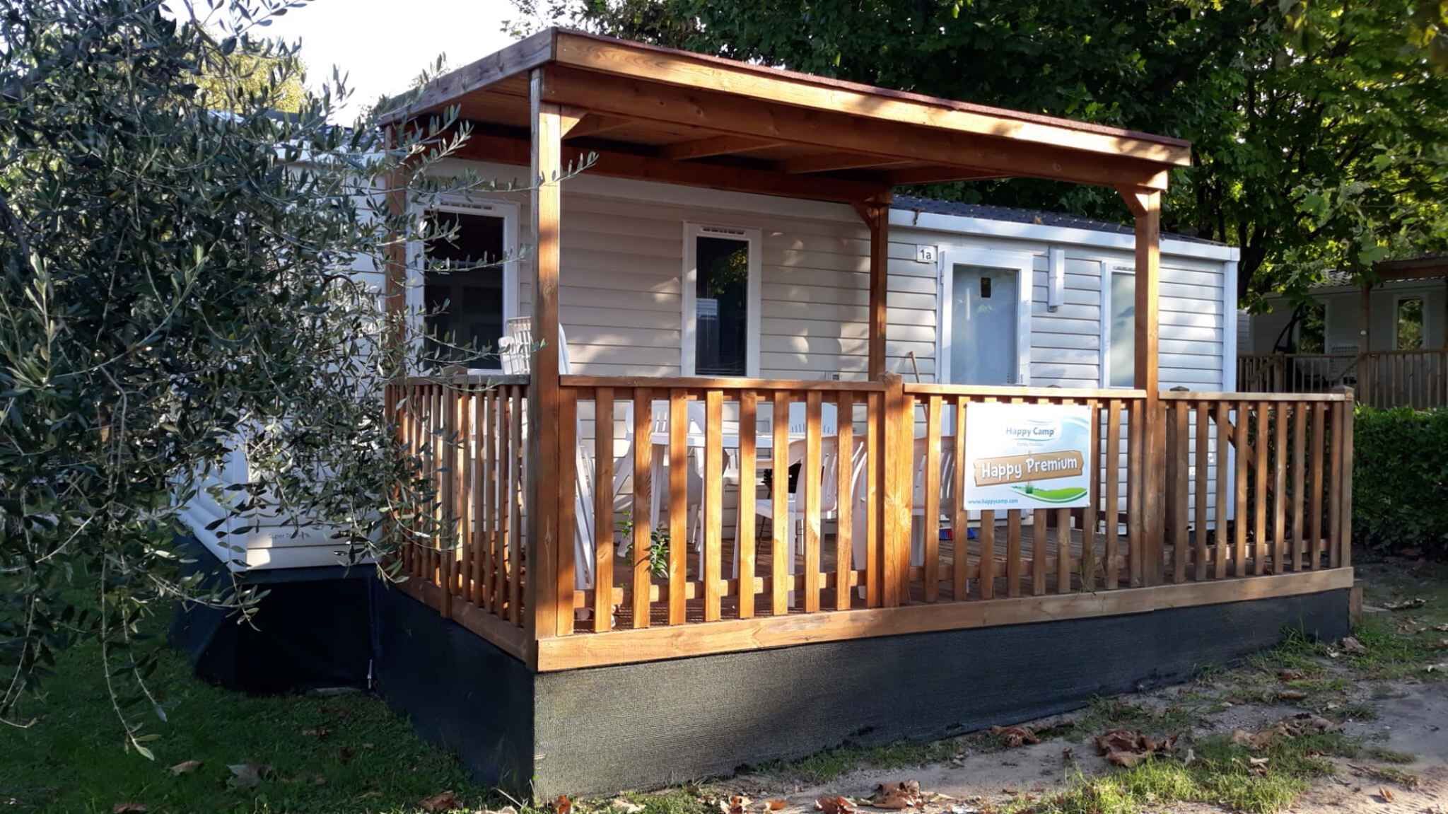 A small cabin with a wooden deck and a covered porch.