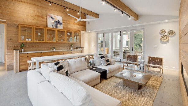 A modern living room with a sectional sofa, a coffee table, and a dining area with a white table and chairs. - Private pool, Luxury furnishings, Elevator, Short walk to beach & town (Folly Beach)