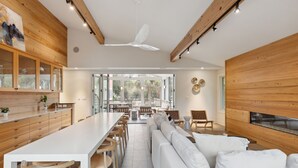 A spacious living area with a long white table, wooden cabinets, and a white sofa. - Private pool, Luxury furnishings, Elevator, Short walk to beach & town (Folly Beach)