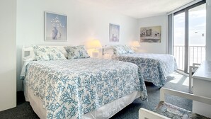 Ein Hotelzimmer mit zwei Betten, einem Balkon und Bildern an den Wänden.