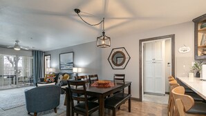 A dining area with a wooden table, chairs, and a hanging light fixture. - Game-Time Getaway 3BR Family Condo w/ 3 baths + Patio | Champions 3-2 (Branson)