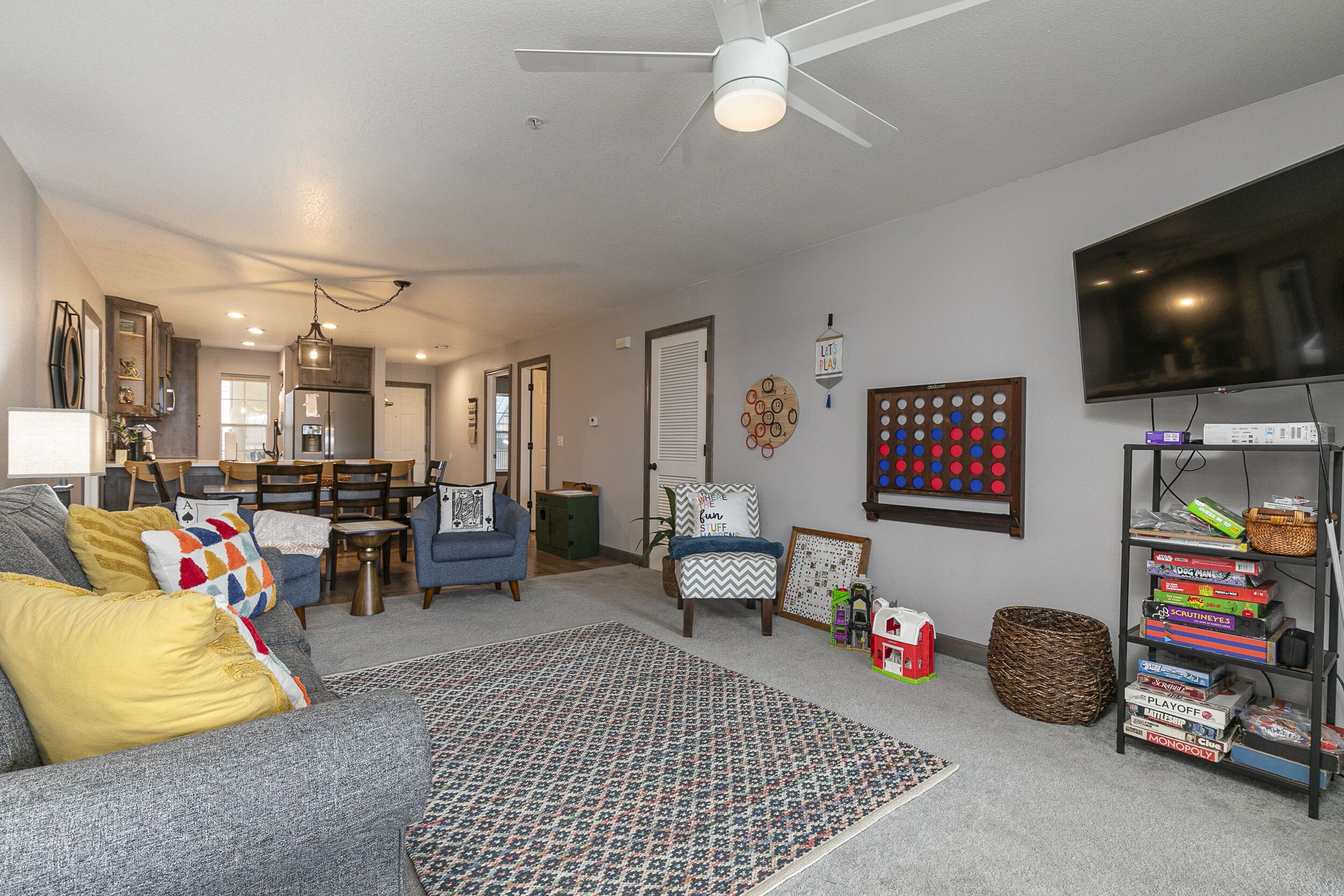 A living room with a gray sofa, patterned rug, and a television on a stand.