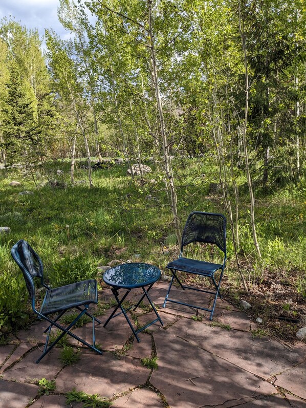 Situated amidst lush greenery, this outdoor seating area invites conversation and relaxation.