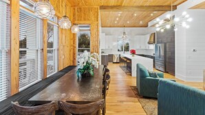 A modern kitchen with white cabinets, a stainless steel refrigerator, and a wooden ceiling. - 12 Periwinkle Ln - Beach Blessings (Santa Rosa Beach)