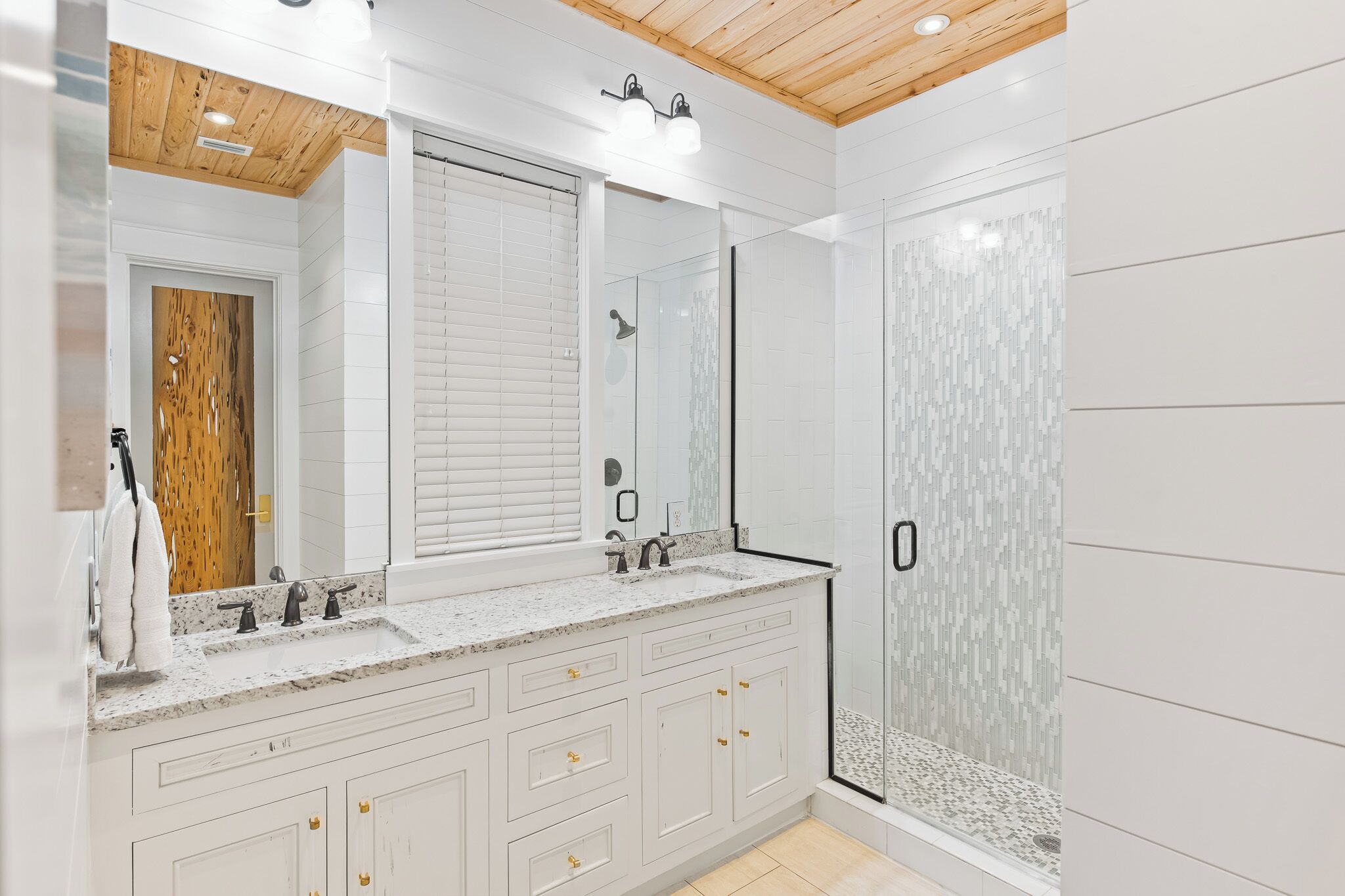 Une salle de bain moderne dotée d’un grand meuble-lavabo, d’une douche à l’italienne et d’un plafond en bois.