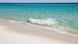A beach with clear turquoise water and a sandy shore. - 12 Periwinkle Ln - Beach Blessings (Santa Rosa Beach)