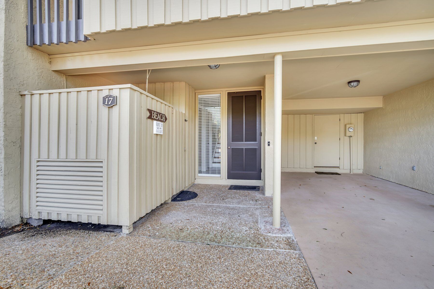 Une entrée d’immeuble avec une façade de couleur beige, un passage couvert et une porte portant le numéro « 17 ».