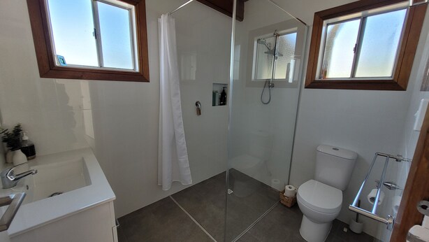 A bathroom with a shower, toilet, and sink. - Mint by the Sea - Esplanade location, sea views! Free WiFi! Off Peak Special! (Tiddy Widdy)