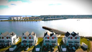 A coastal hotel with multiple buildings, a dock, and a calm sea. - Maisonette Fewo Ostseeflair Erste Wasserreihe, Panoramablick, by Seeblick Ferien (Kappeln)