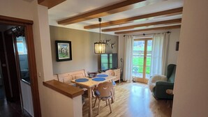 Een modern interieur met een eethoek, een bank en een televisie.
