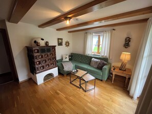 A cozy living room with a green sofa, wooden cabinet, and a lamp.