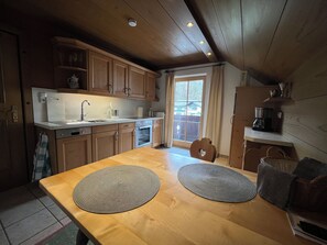 Una cocina con gabinetes de madera, una encimera y una mesa de comedor con individuales.