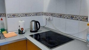 A kitchen with a stove, a kettle, and a range hood. - Ellite XIii Apartment Playa Naufragos Torrevieja! (Torrevieja)