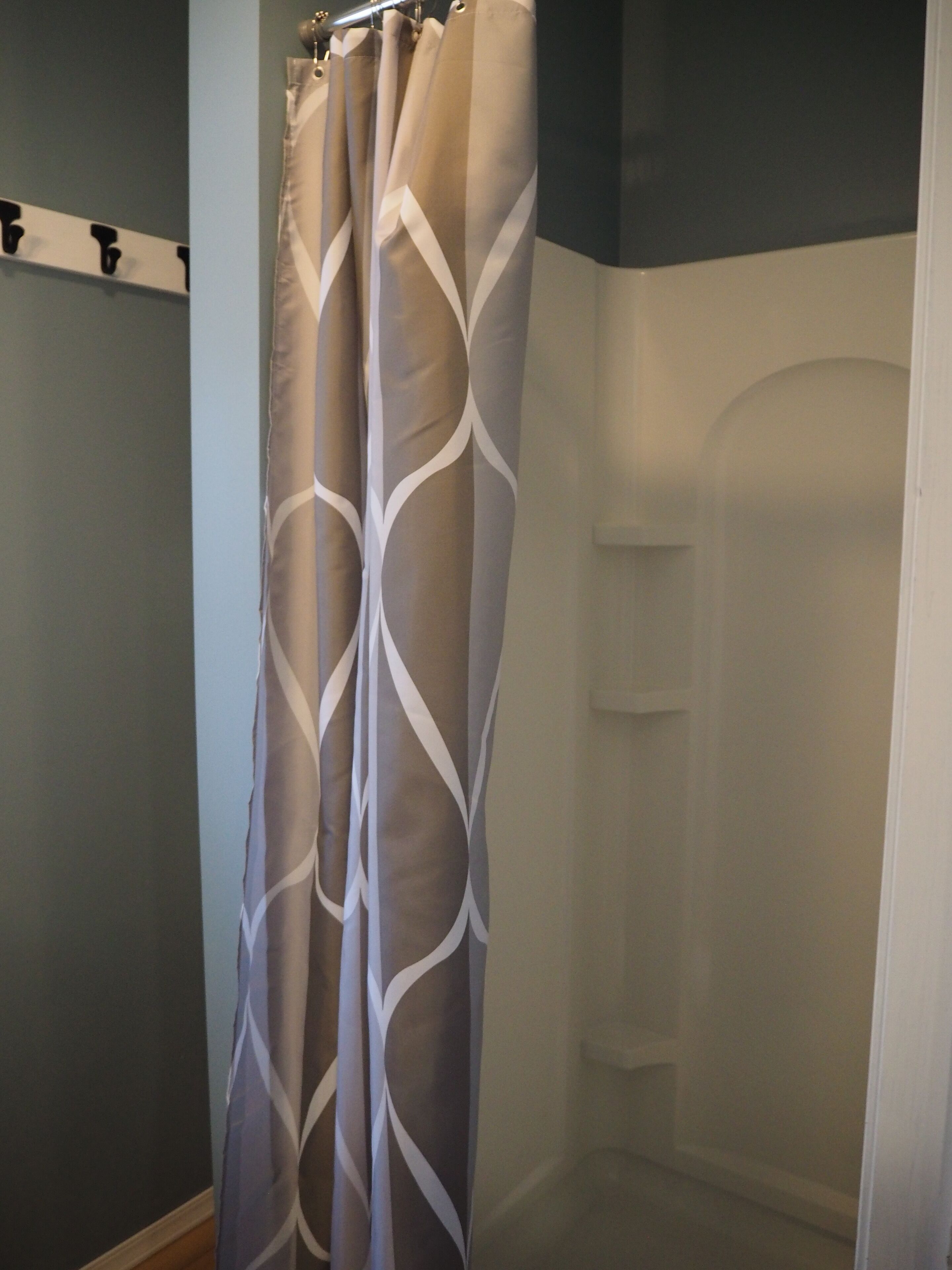 A bathroom with a shower curtain featuring a geometric pattern.
