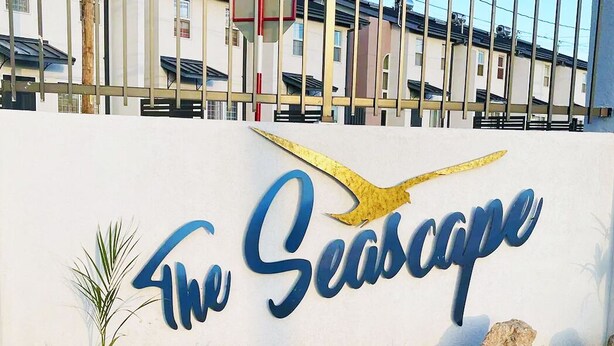 Señal que dice "The Seascape" con un gráfico de un ave estilizado.