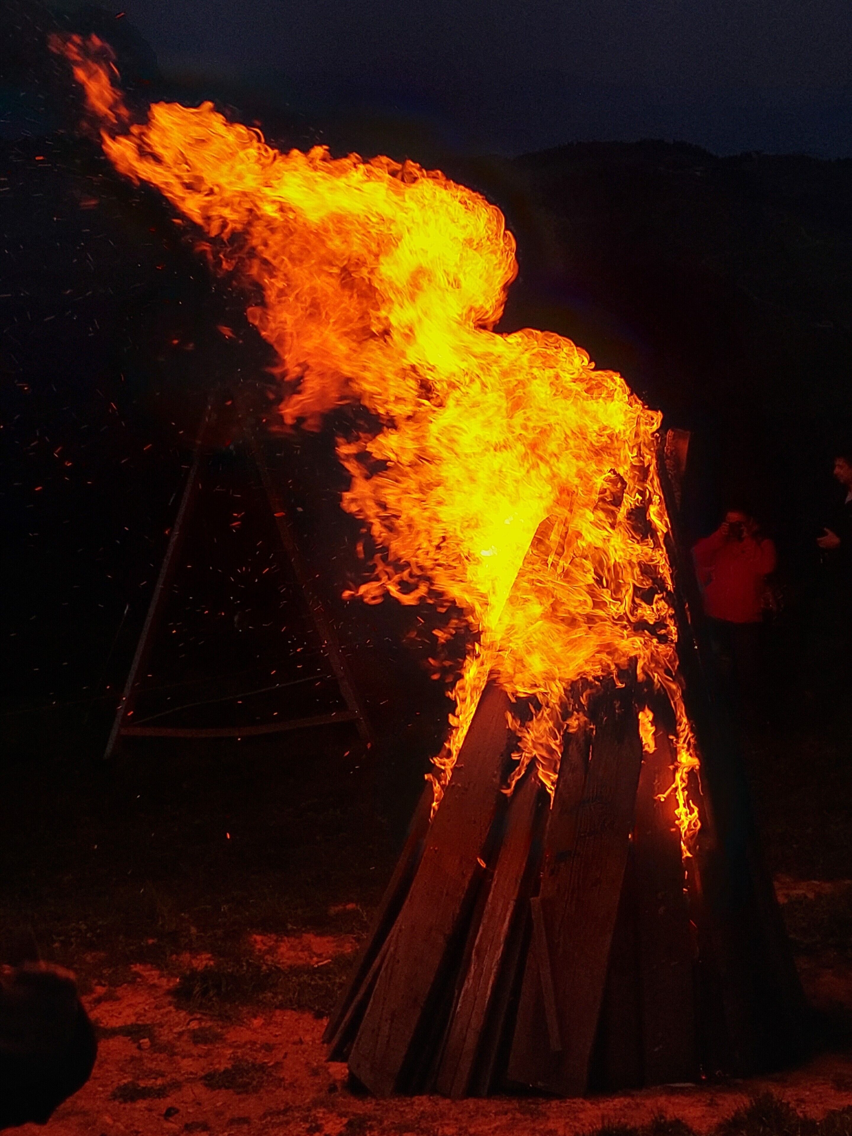 A fire burning on a pile of wooden logs.