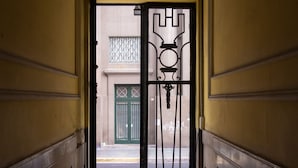 A staircase leading to a door with a metal gate and a sign indicating a 'CABAL' entrance. - Sevilla home Hotel (Buenos Aires)