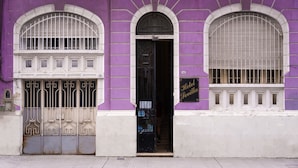 A building with a purple facade, a black door, and a sign reading "Hotel Sevilla". - Sevilla home Hotel (Buenos Aires)