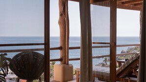 Um deck de madeira com uma grande janela vista para o oceano.