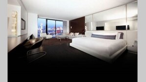 A modern hotel room with a large bed, a seating area with a view of the city, and a large window. - Not Available  51-303 floor (Las Vegas)