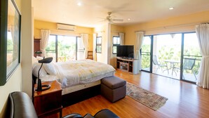 A spacious bedroom with a large bed, a television, and a balcony with outdoor furniture. - Pool Villa with maid service- walk to white sand beach! (Paknampran)