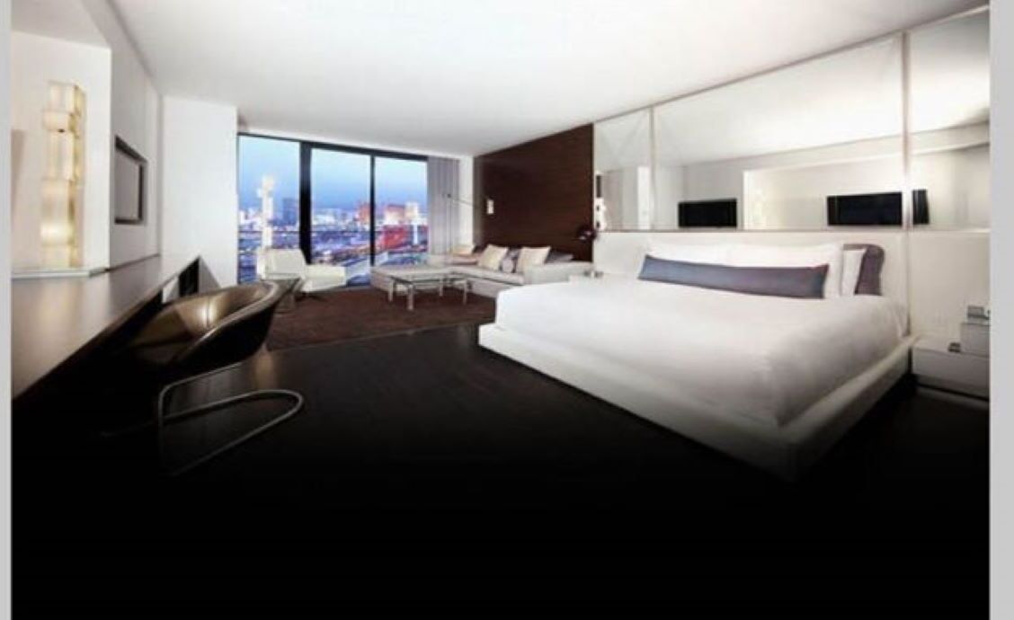 Ein modernes Hotelzimmer mit einem großen Bett, einer Sitzecke mit Blick und einem Schreibtisch.