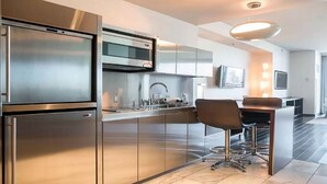 A modern kitchen with stainless steel appliances, a bar area, and a large window. - Palms Place Amazing High Rise Suite 21-305 (Las Vegas)