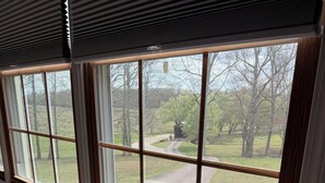 A room with two large windows, a wooden floor, and a visible outdoor pathway. - Peaceful Country Home w/Covered Bridge (Athens)