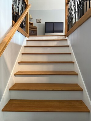 Eine Treppe mit Holzboden und schwarzen Metallgeländern.