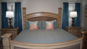 A double bed with a wooden headboard, two nightstands with lamps, and a dresser with drawers. - 3bed/2bath pool home, sleeps 8 guests, great location, private/sunny aspect. (Davenport)